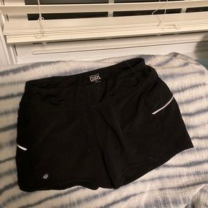 Athleta Girl black active shorts with teal zipper on back waistband